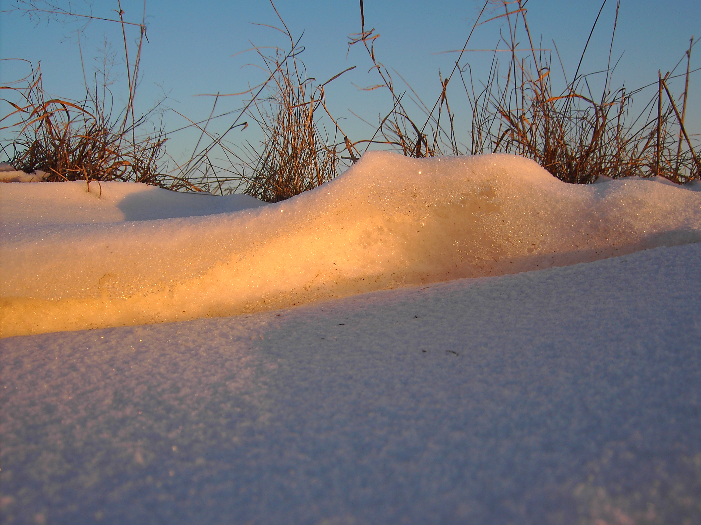 "Schneedünen" an einem Feldweg im Sonnenaufgang